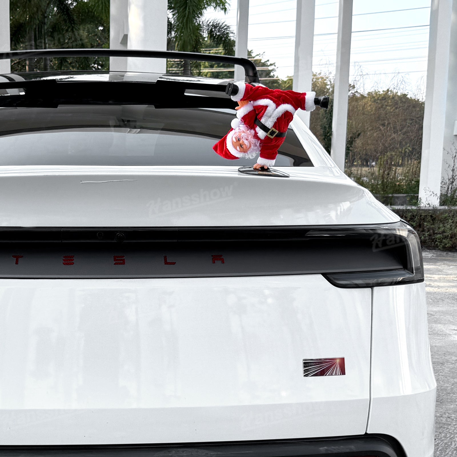 Santa Claus performing spins in Tesla Model Y trunk